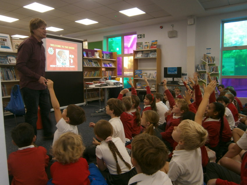 Image of Year 3 and 4 children enjoy the antics of Horrible Science author Nick Arnold